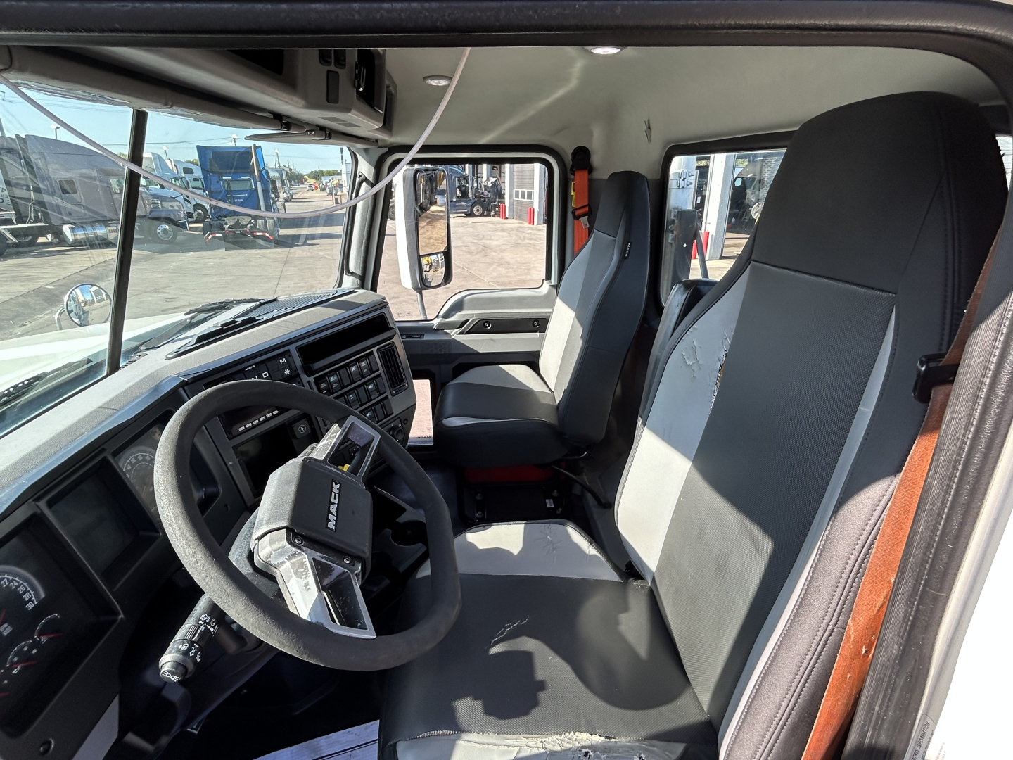 Interior of a 2020 Mack PI64T truck cab showing steering wheel, driver's seat, and dashboard with digital gauges and controls.