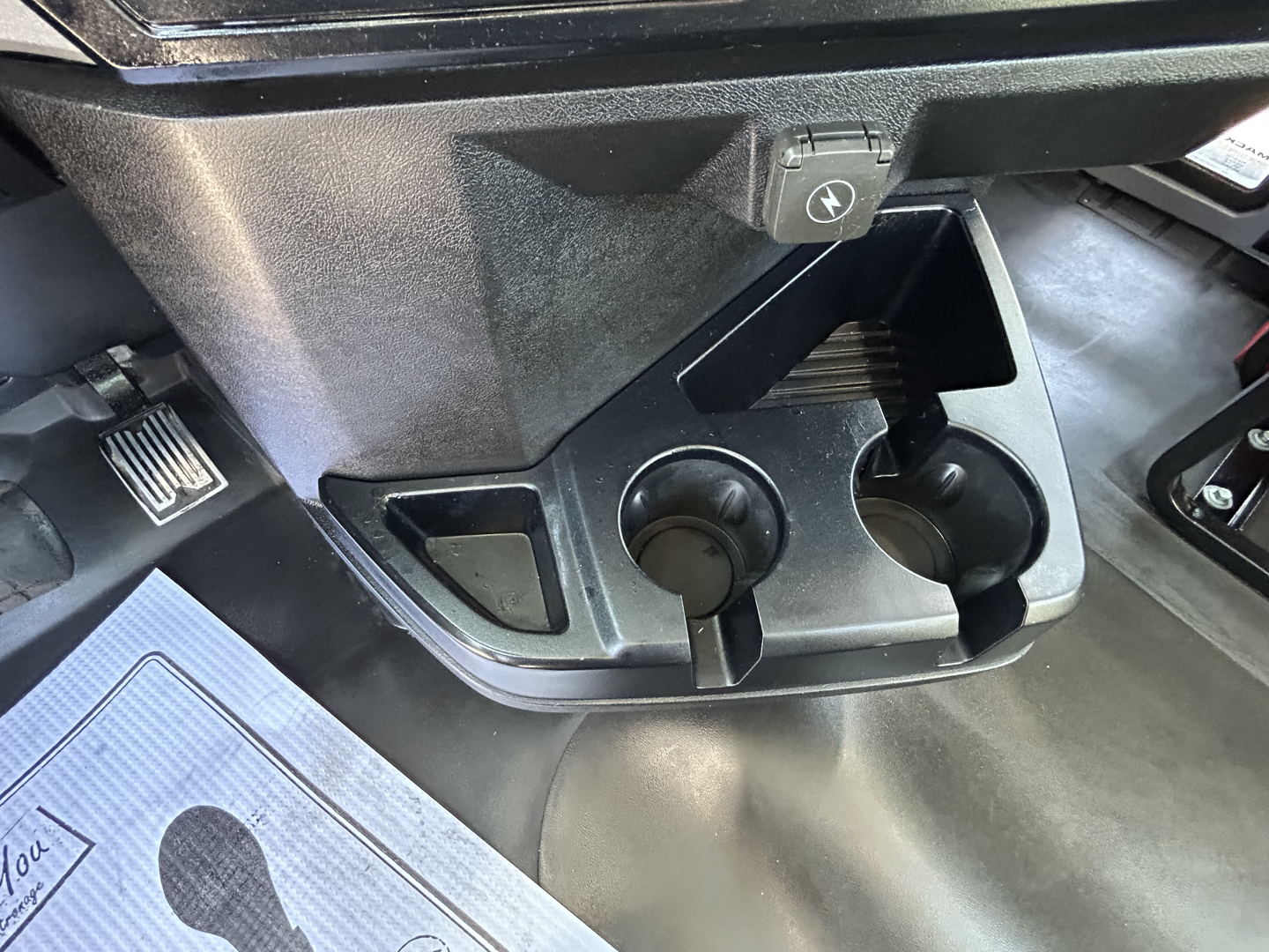 Mack PI64T cab interior showing cup holders and ignition area with 12V plug and dash area