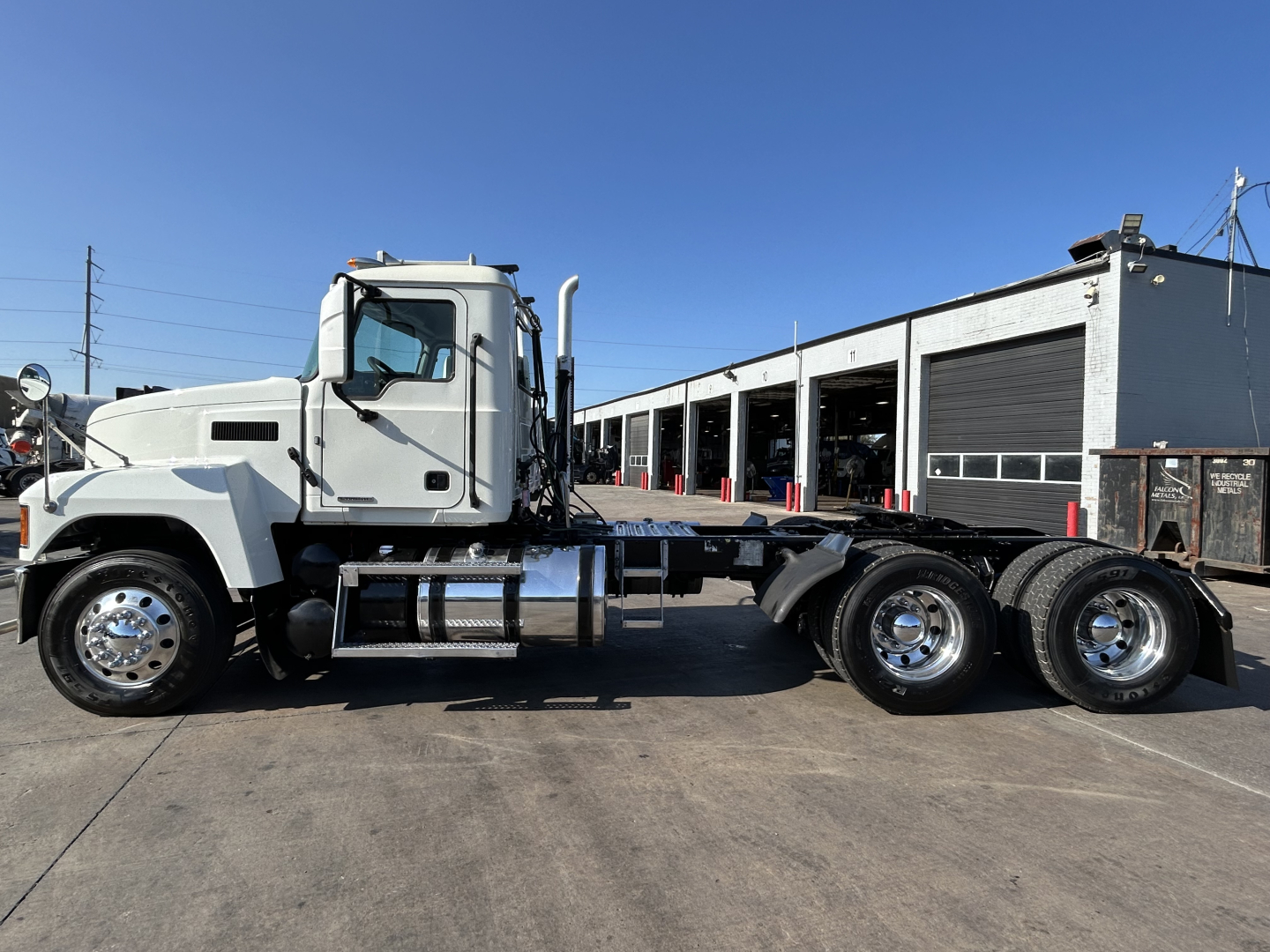 White Mack PI64T conventional daycab truck side profile showing cab, chassis frame, and dual rear axles with chrome wheels.