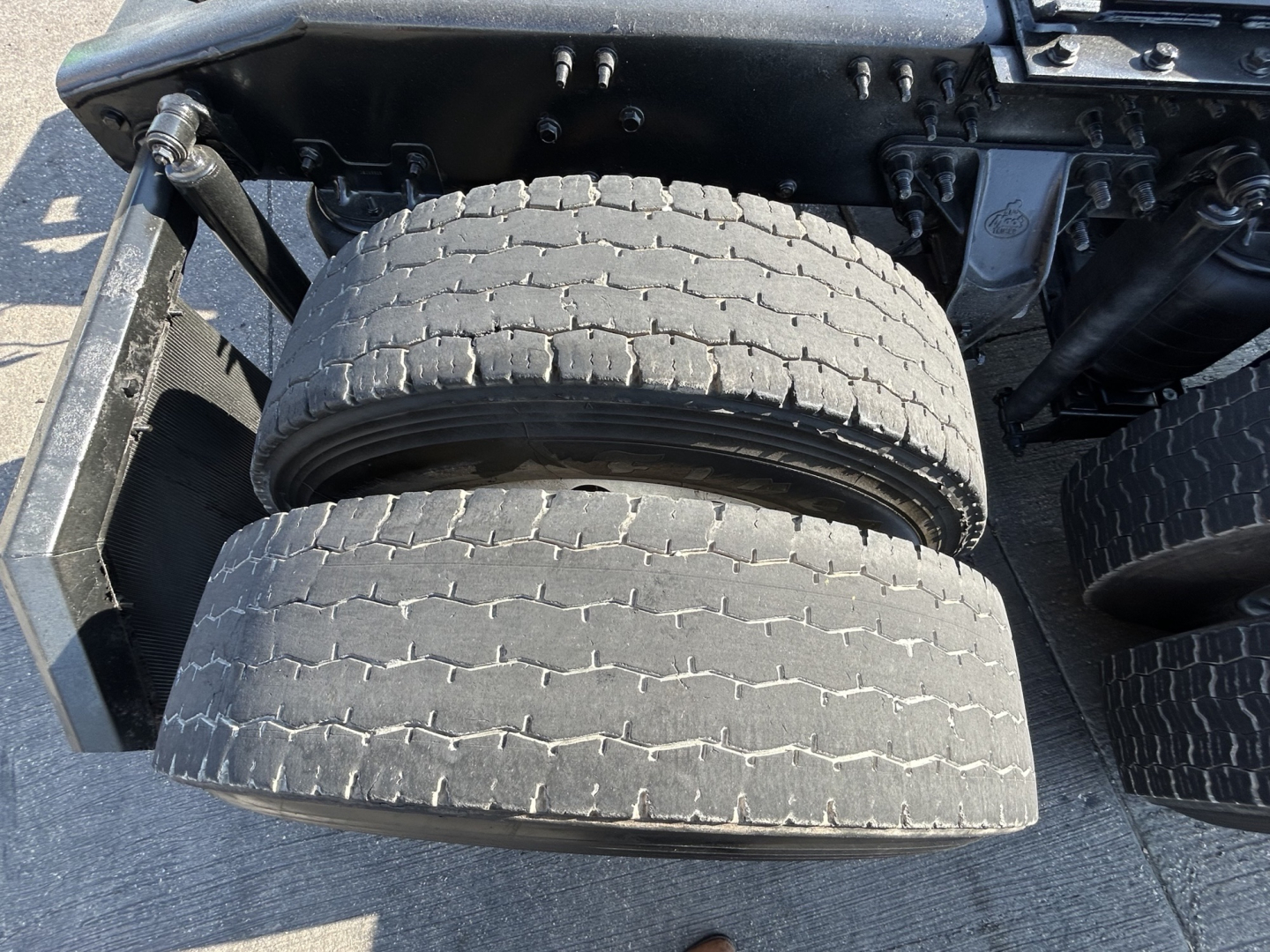 Mack PI64T truck chassis showing dual rear drive tires and wheel area.