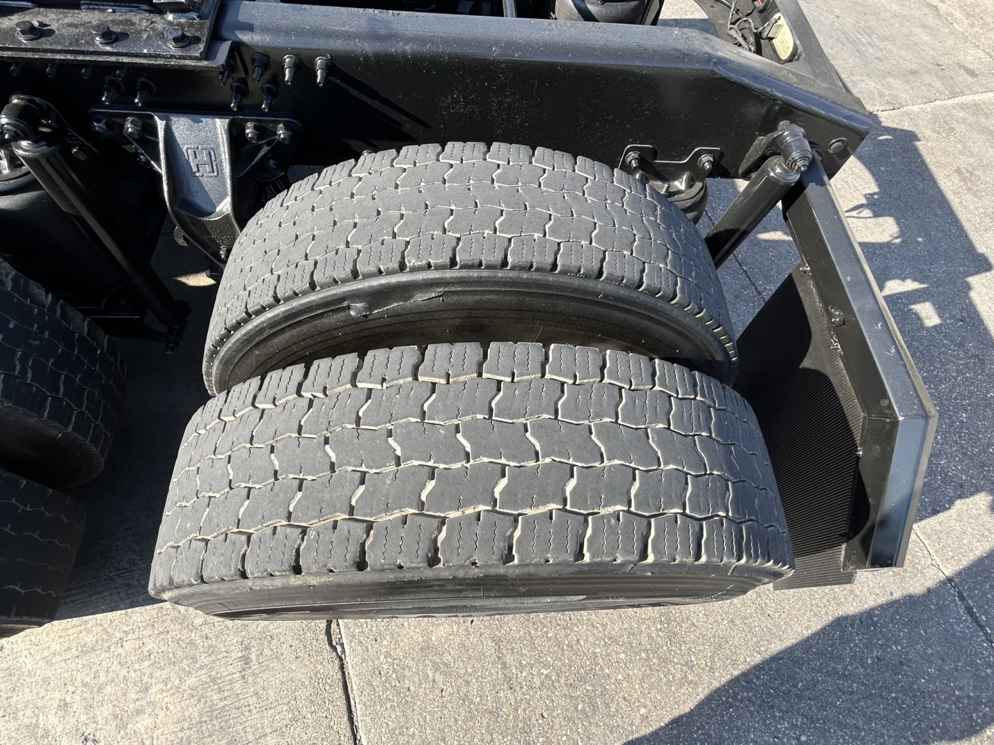 Rear axle dual tires on Mack PI64T truck showing paired heavy-duty tires and chassis components.