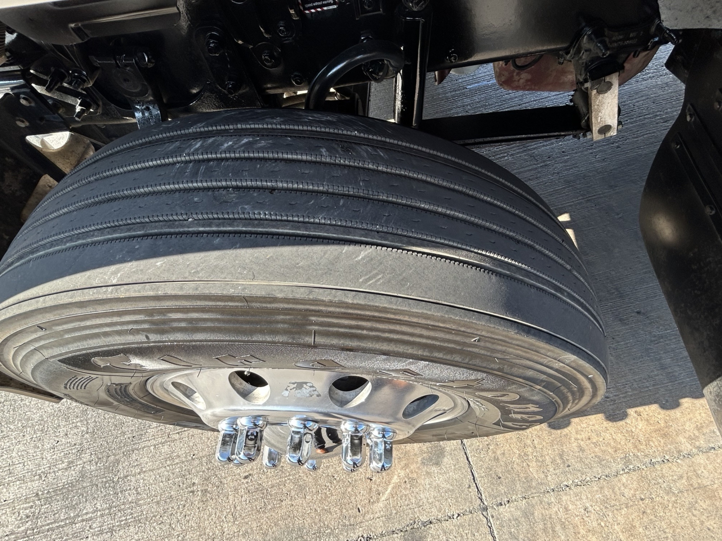 Mack PI64T truck undercarriage showing a wide dual rear axle wheel and mounting studs.