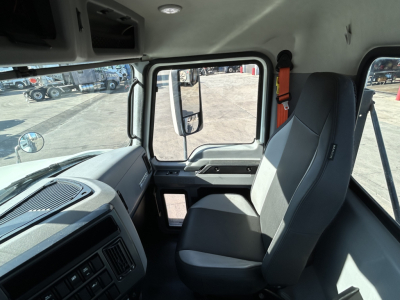 Cab interior of a 2020 Mack PI64T showing driver seat, steering wheel, dashboard, and door panel.