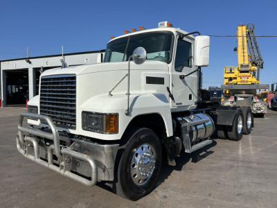 Truck: 2020 Mack PI64T conventional daycab with front bull bar, dual round mirrors, mounted fuel tanks, and a heavy-duty crane in background.