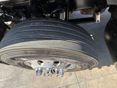 Mack PI64T truck undercarriage showing a wide dual rear axle wheel and mounting studs.