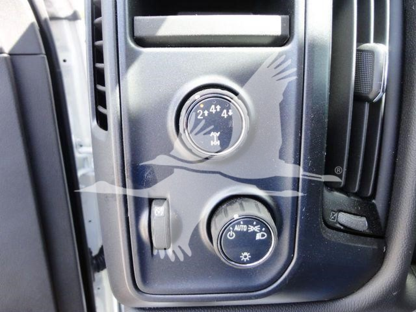 Dashboard controls of a 2023 International CV dump truck showing four-wheel drive selection knob with 2WD 4x4 markings and a separate circular switch labeled AUTO and a sun icon.