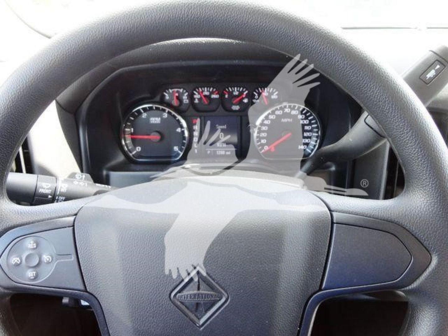 Dashboard and steering wheel of a 2023 International CV dump truck showing instrument cluster and steering wheel emblem.