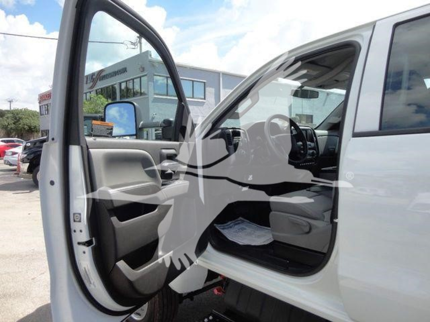 Interior view of a white 2023 International CV dump truck with front left door open, showing steering wheel, driver's seat, and dashboard.