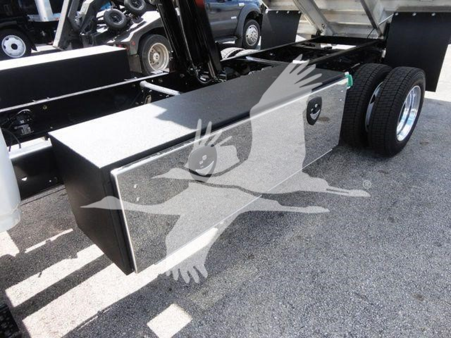 Dump truck bed toolbox and dual rear wheels showing storage box and chassis
