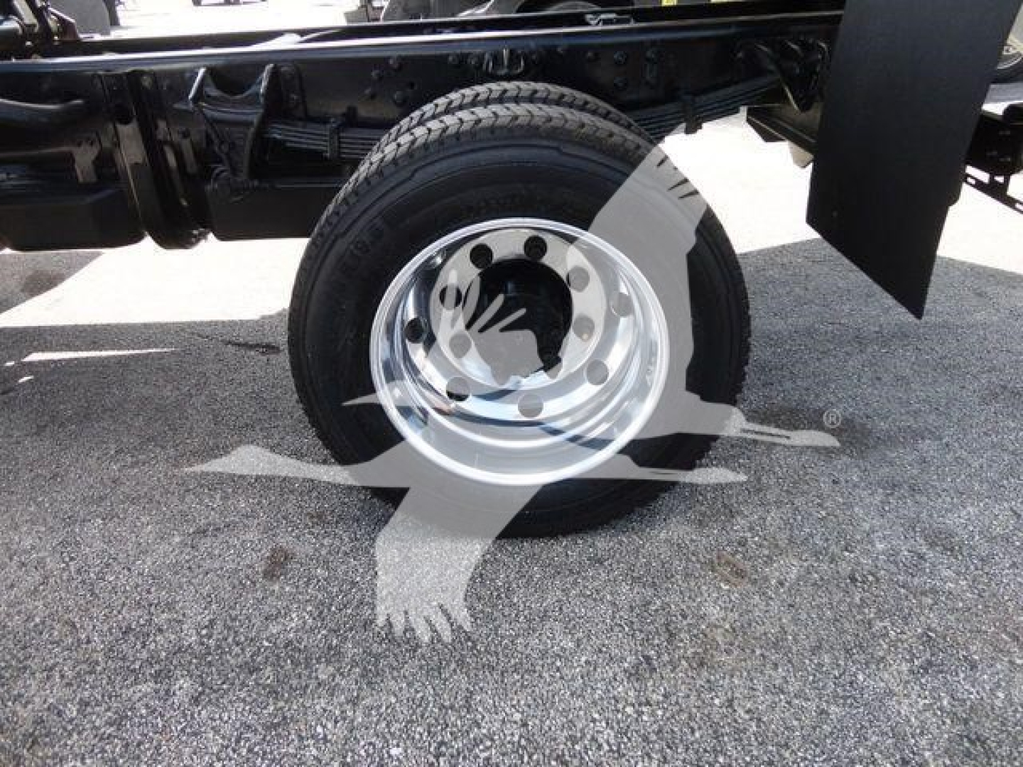 Truck wheel and chassis components visible with steel rim and tire, part of International CV dump truck chassis.