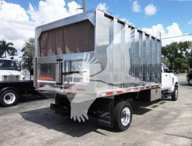 Dump truck with silver cargo body and cab, side rear view showing flatbed truck bed and wheel, International CV model likely, stock no. 4X4CV14CHIPPER.