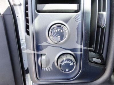 Dashboard controls of a 2023 International CV dump truck showing four-wheel drive selection knob with 2WD 4x4 markings and a separate circular switch labeled AUTO and a sun icon.