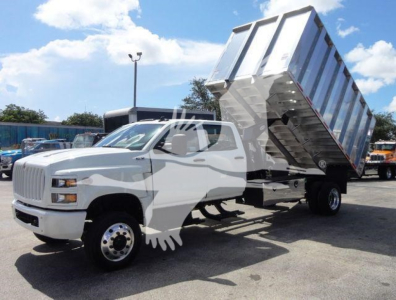 Truck cab with a hydraulic dump bed raised, white International CV model in a lot, 4x4 chipper stock number 4X4CV14CHIPPER.