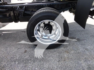 Truck wheel and chassis components visible with steel rim and tire, part of International CV dump truck chassis.