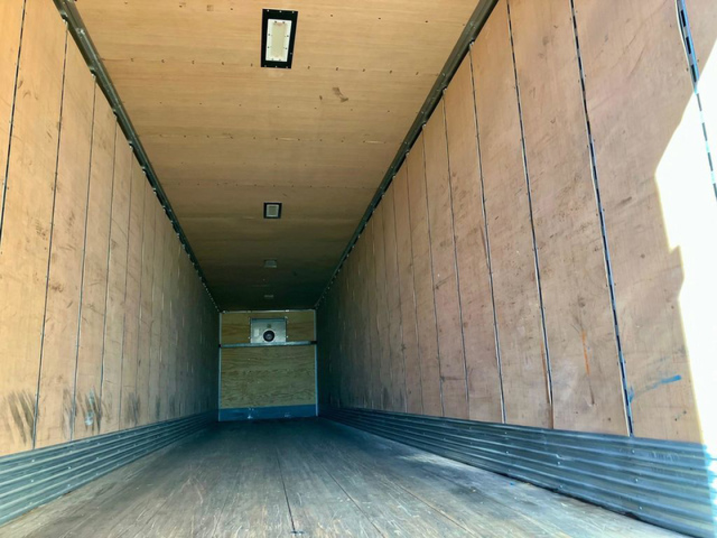 Trailer interior showing wooden walls and ceiling of a used 2020 Great Dane dry van trailer, empty cargo area with metal strip at floor edge and small vent in ceiling.