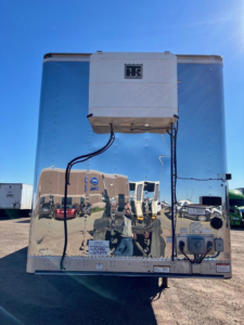 Rear view of a 2020 Great Dane dry van trailer showing refrigeration unit and electrical connections on reflective aluminum surface.