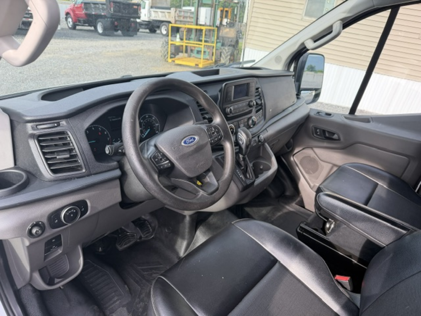 Ford Transit/Truck interior showing steering wheel, dashboard, and center console with touchscreen display.