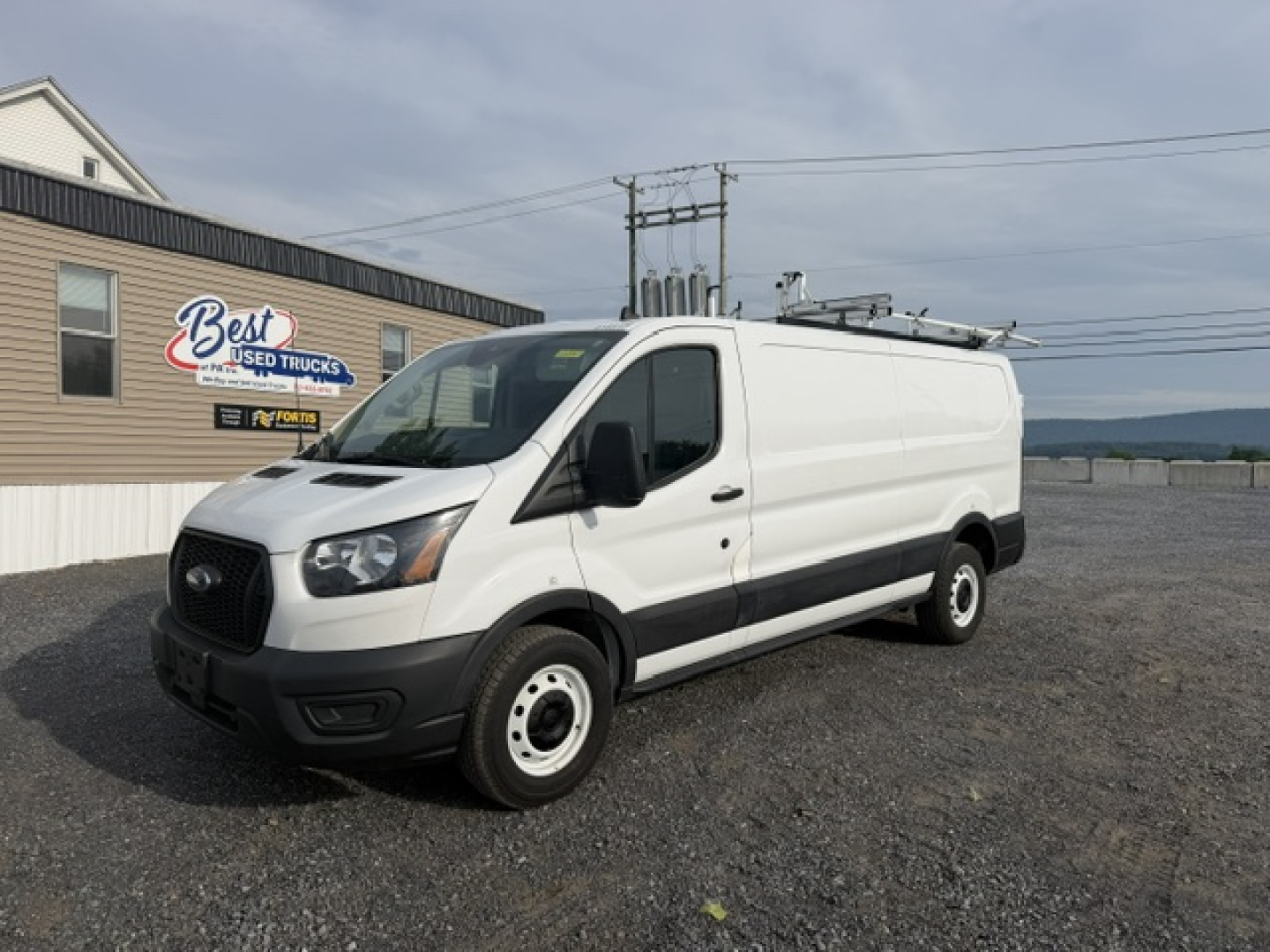 Ford TRAN250 cargo van in service/utility category showing front and side view with white body, black bumper, and ladder rack.