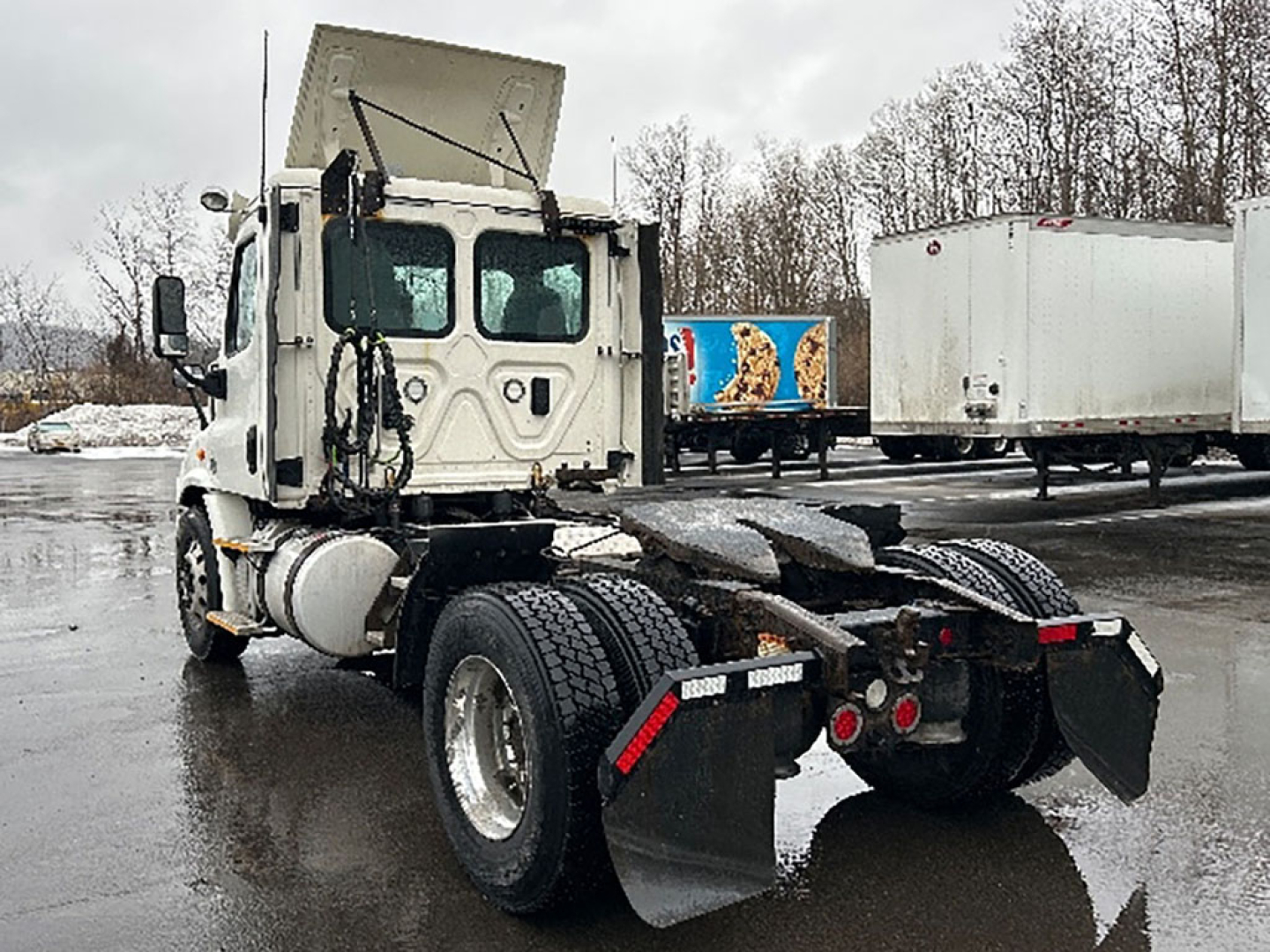 Freightliner Cascadia Daycab tractor rear and cab view showing chassis and dual rear axles with mud flaps.