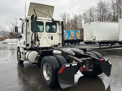 Freightliner Cascadia Daycab tractor rear and cab view showing chassis and dual rear axles with mud flaps.