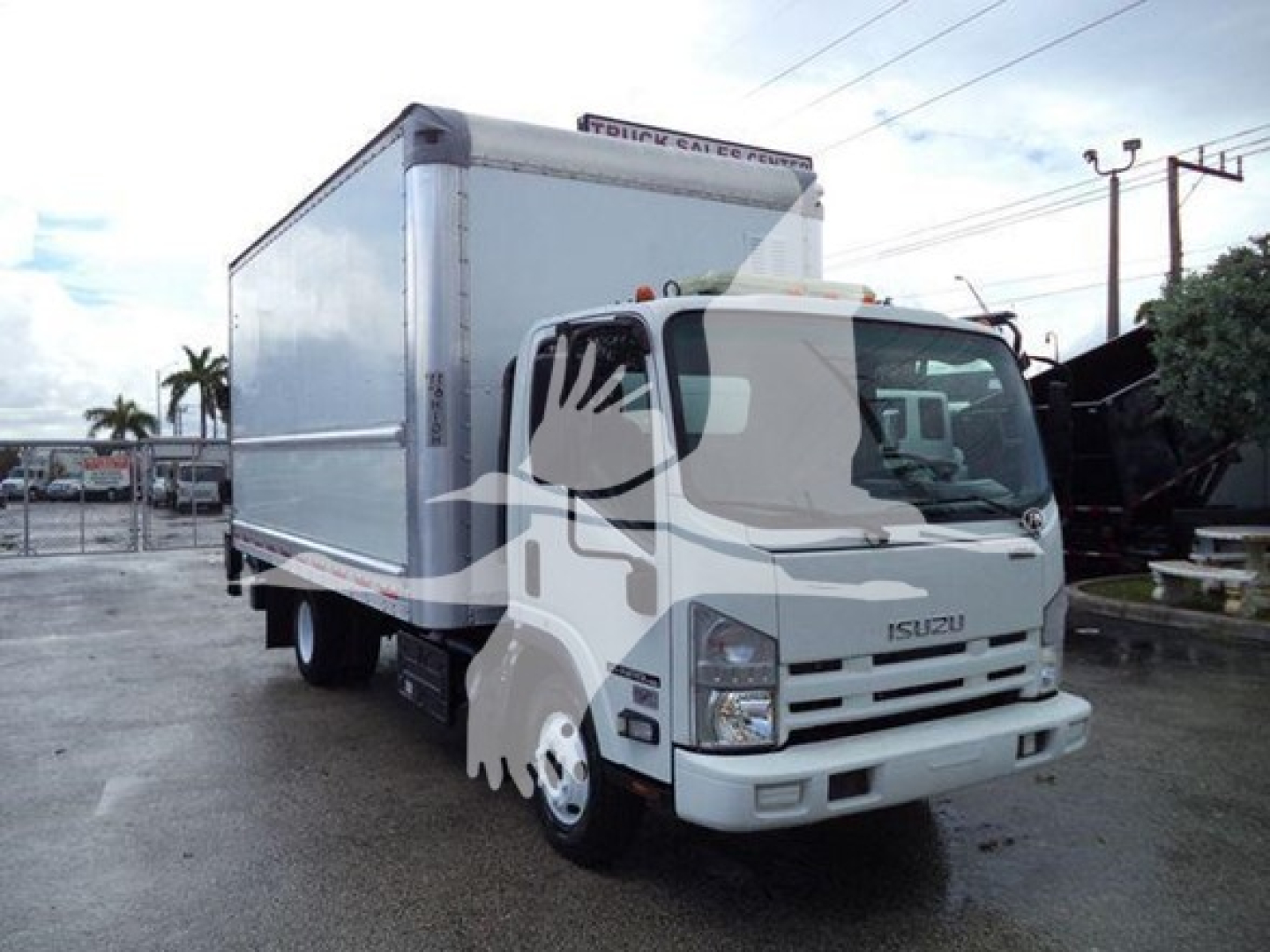 Isuzu NPR HD box truck side/front view showing cab and cargo box with identification stickers