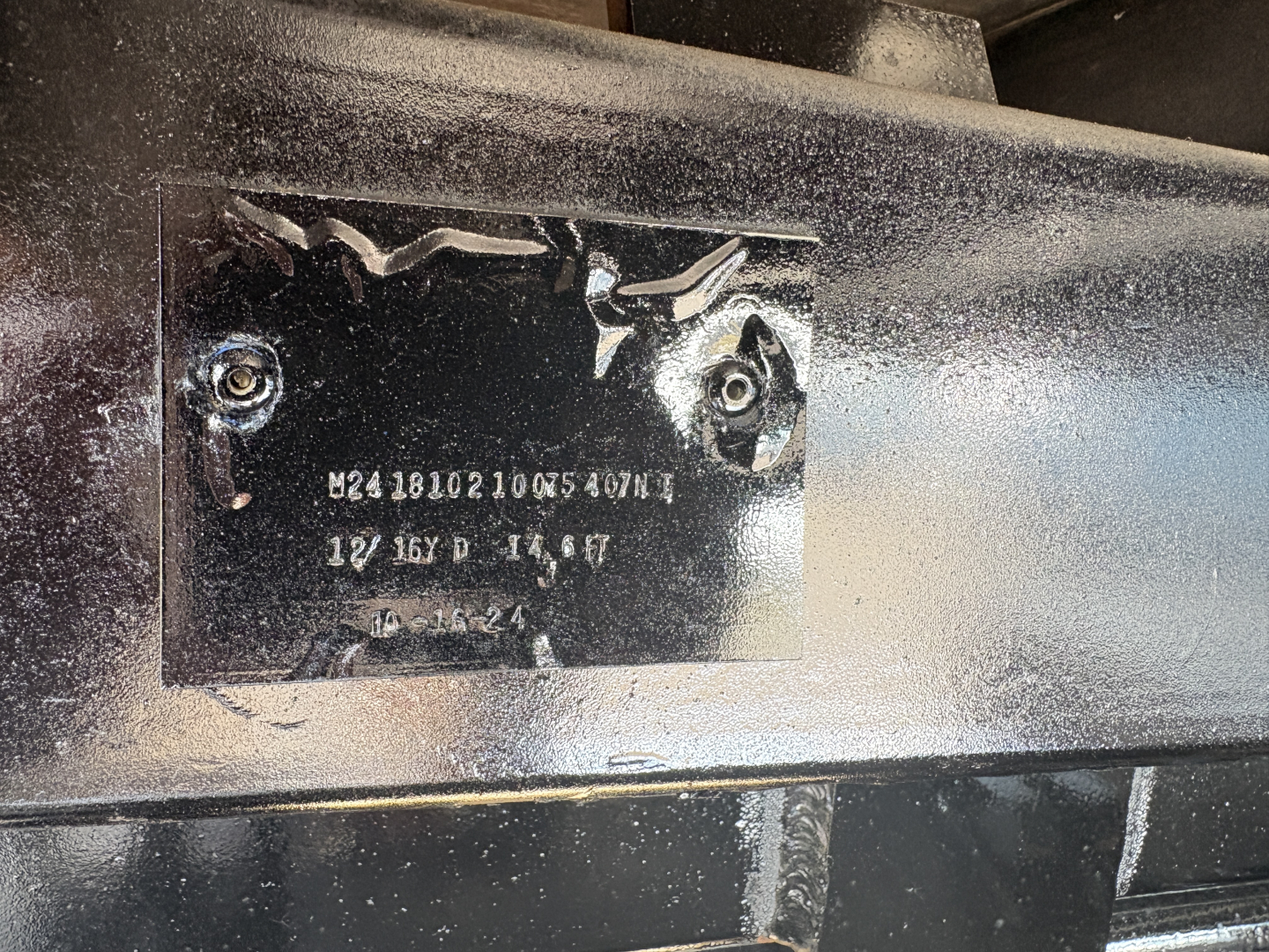 Plate on Mack GR64F showing serial/ID markings and alphanumeric codes.
