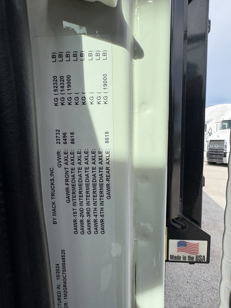 Label on vehicle showing GVWR and axle ratings and manufacturer info. Text includes columns with weights (KG/ LB), front and rear axle specs, and a note about Mack Trucks Inc. Made in USA sticker visible.
