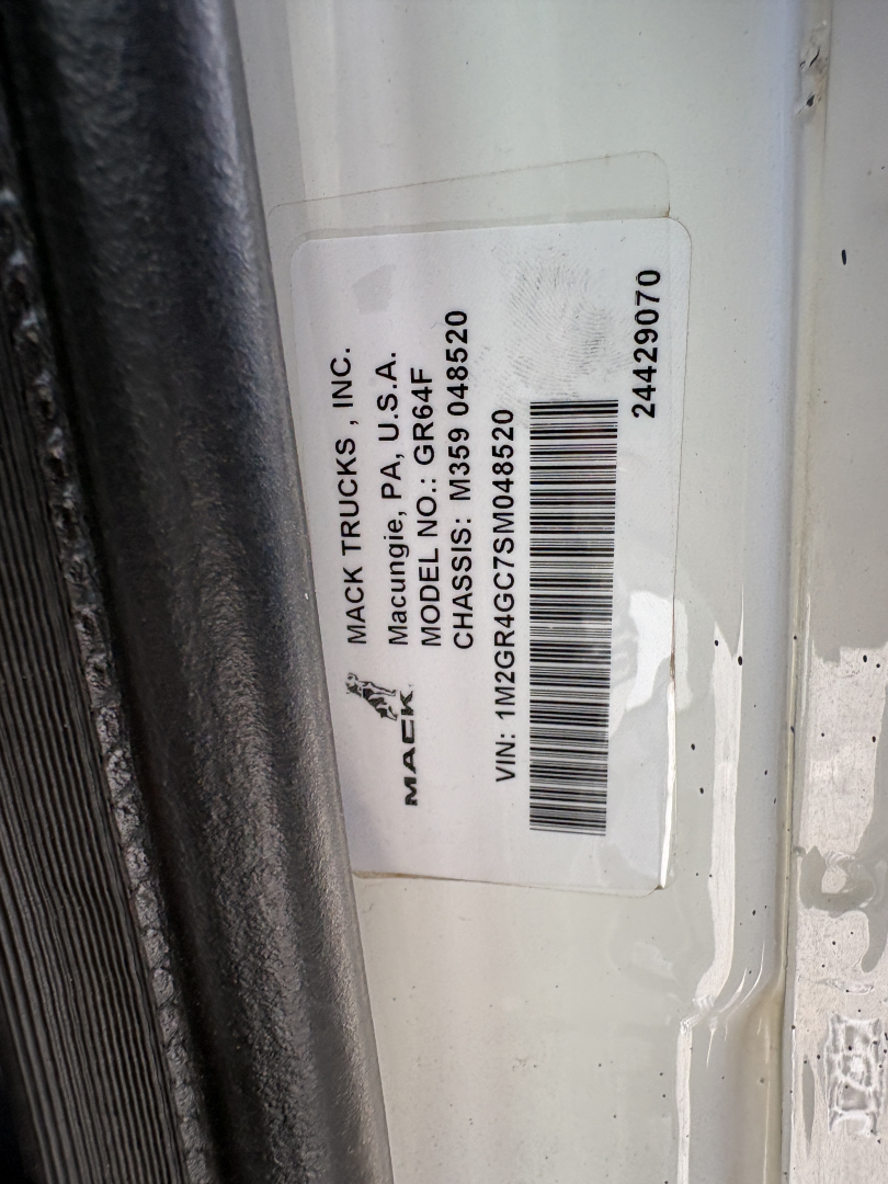 Mack Trucks label on door jamb with VIN 1M2GR4GC7SM048520 and model/serial information clipped sticker.
