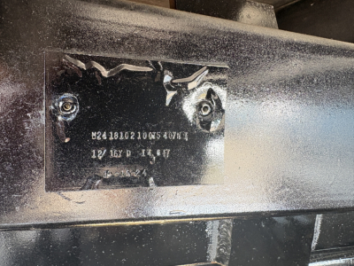 Plate on Mack GR64F showing serial/ID markings and alphanumeric codes.