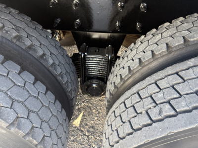 Mack GR64F chassis showing rear dual tires and leaf spring suspension with drive-hub and undercarriage components.
