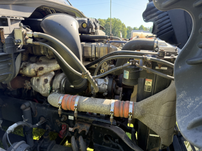 Truck engine bay of a 2016 Freightliner Cascadia Evolution showing fuel lines, coolant hoses, turbocharger, belts, and various engine components.