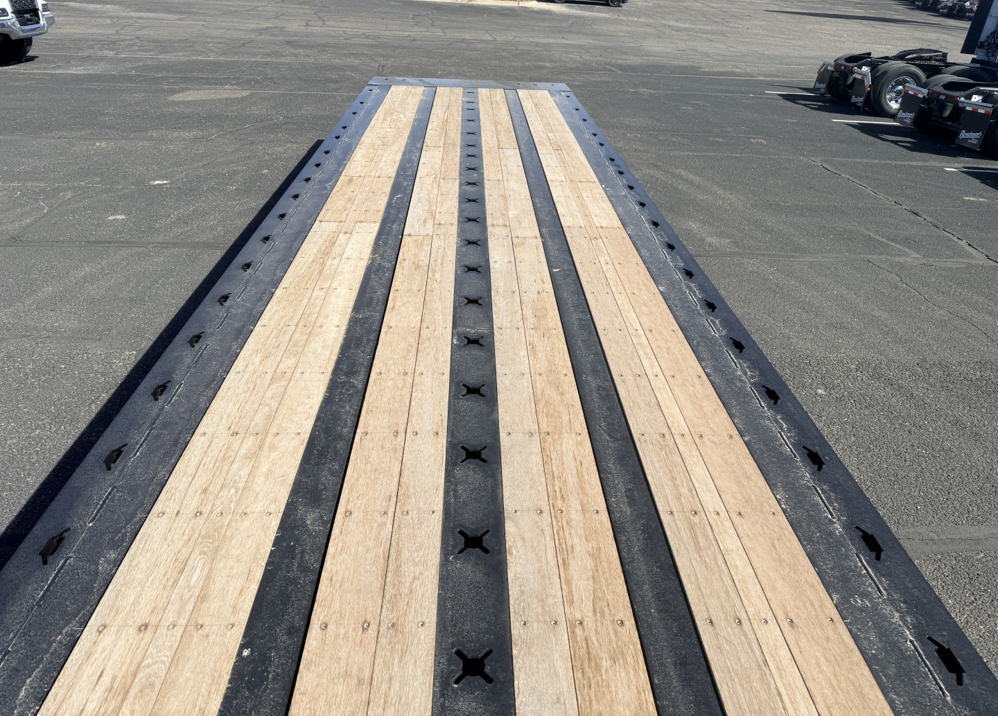 Landing view of a 40-ton Landoll trailer deck with wooden planks and black steel center rails.