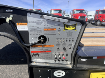 Landoll 440B-53 trailer control panel with warning labels and Andoll logo visible, showing numerous switches and instruction text.