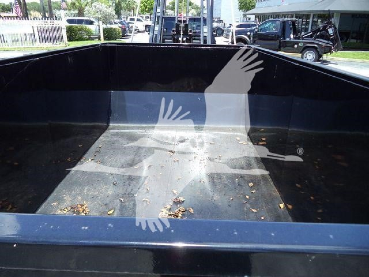 Truck bed of a 2024 Ram 5500 SLT hooklift medium-duty truck showing empty cargo area with dark interior and reflections.
