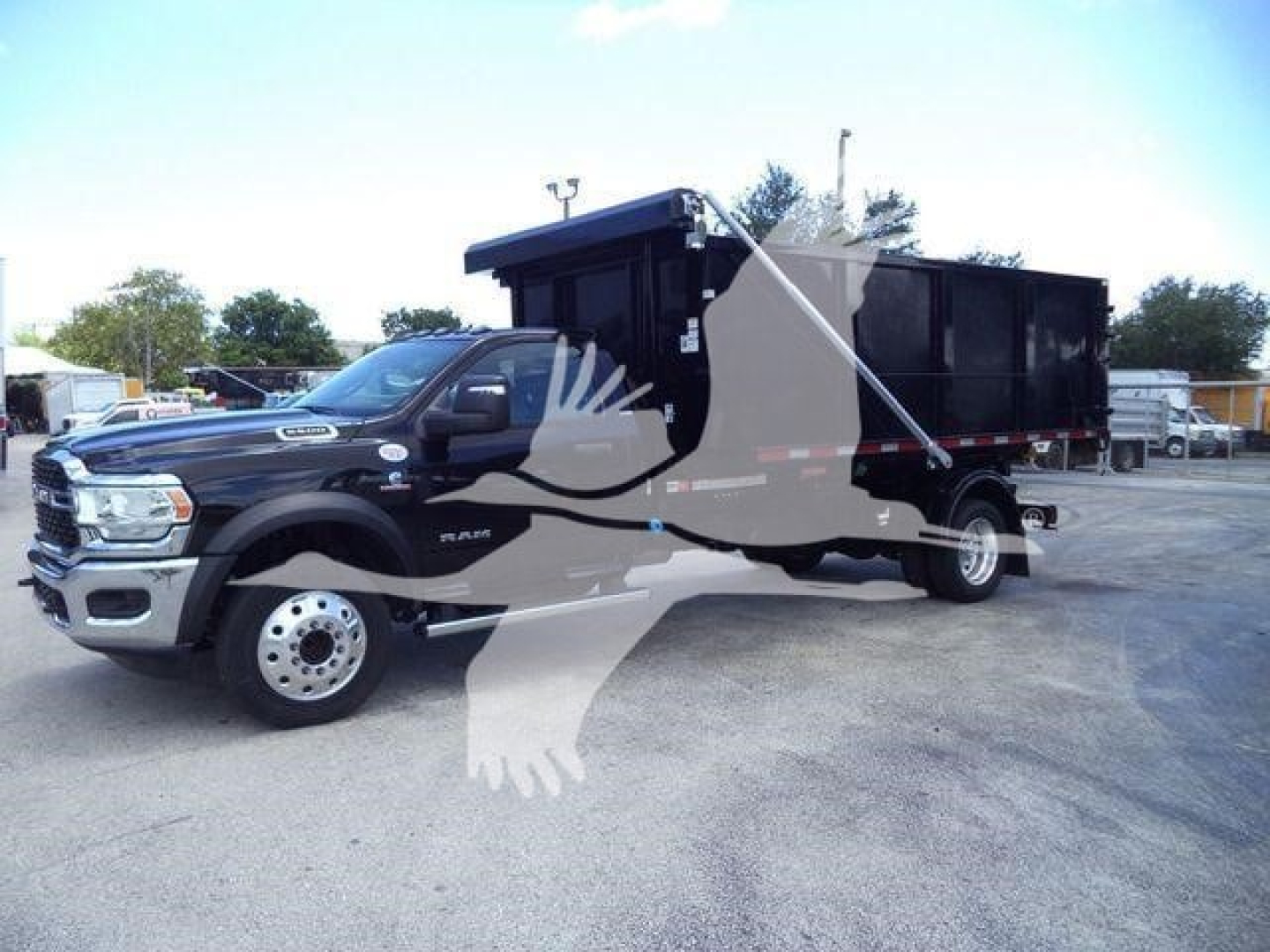 Ram 5500 dump/dump-bed hooklift truck in side view showing black dump bed and cab, 'Ram' badge visible.