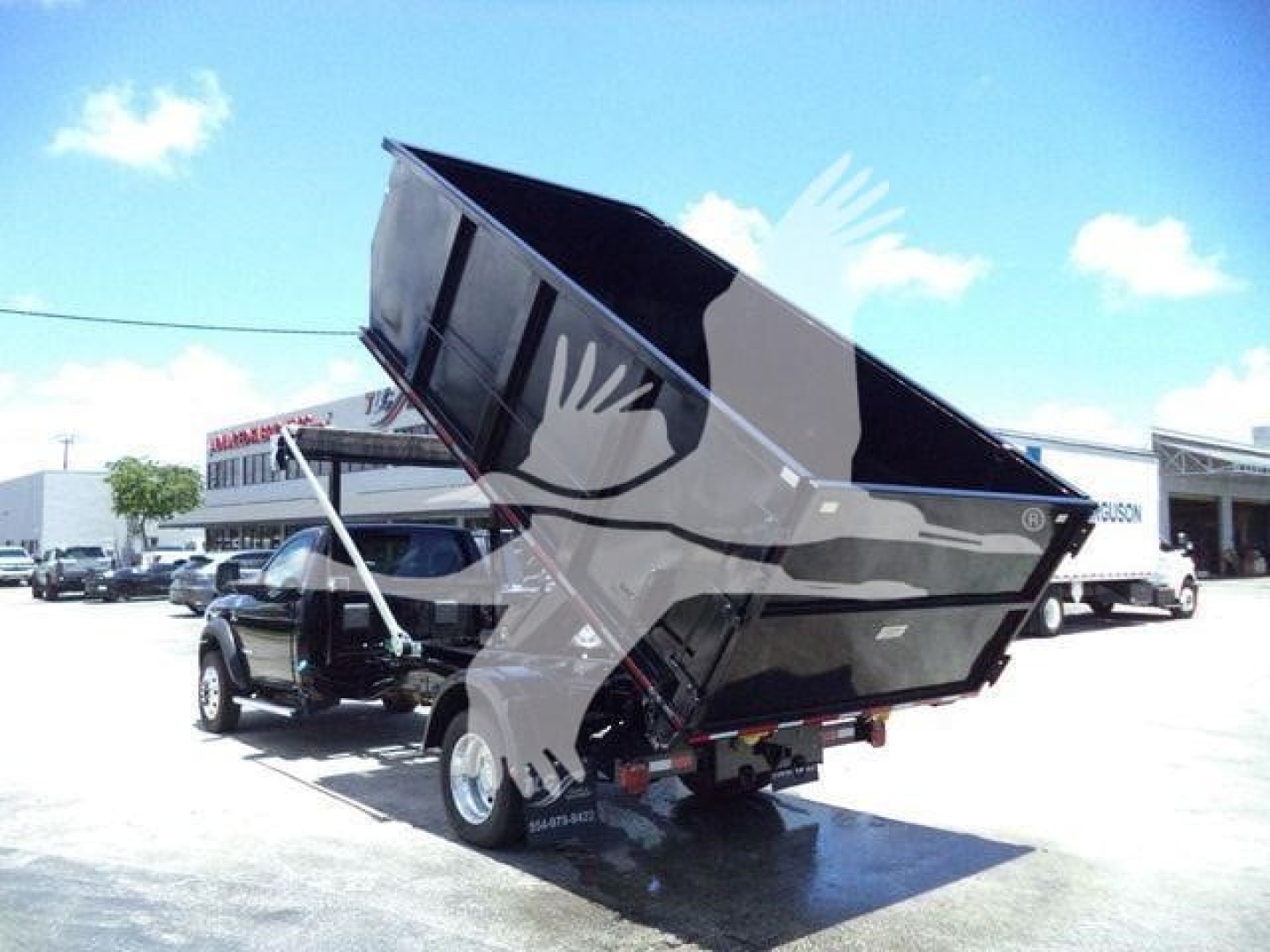 Ram 5500 dump bed/hooklift truck rear view with bed raised showing cargo bed and hydraulic cylinder.