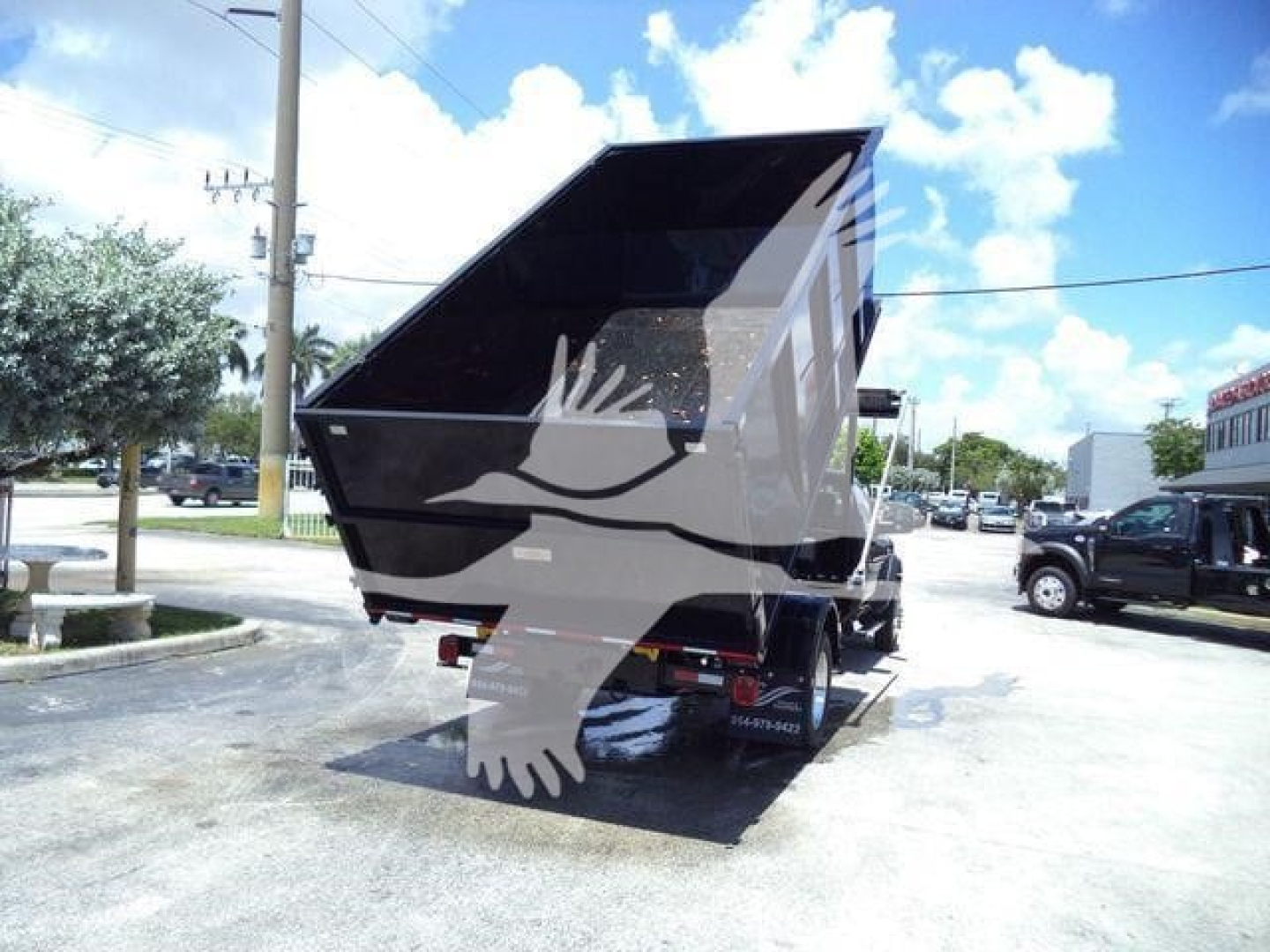 Truck bed or dump hopper attached toRam 5500 rear, rear view showcasing black dump body with raised sides. No visible text readable.