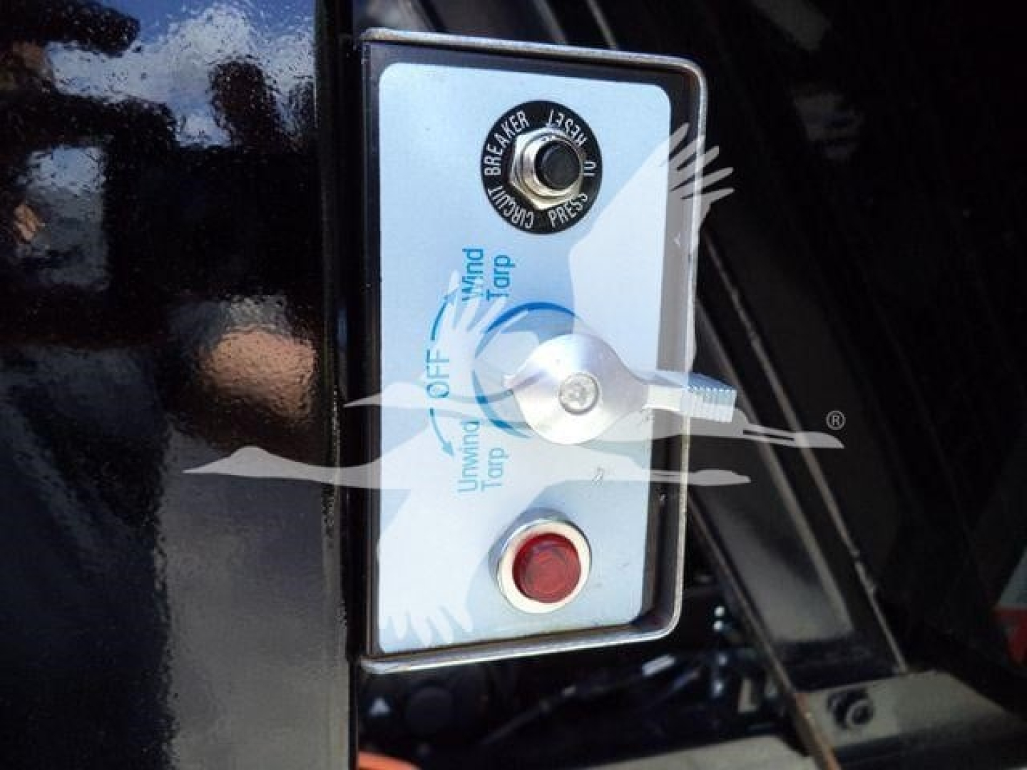 Ram 5500 Hooklift control panel with ignition key switch and red start button, showing labels for pressure and turning directions.