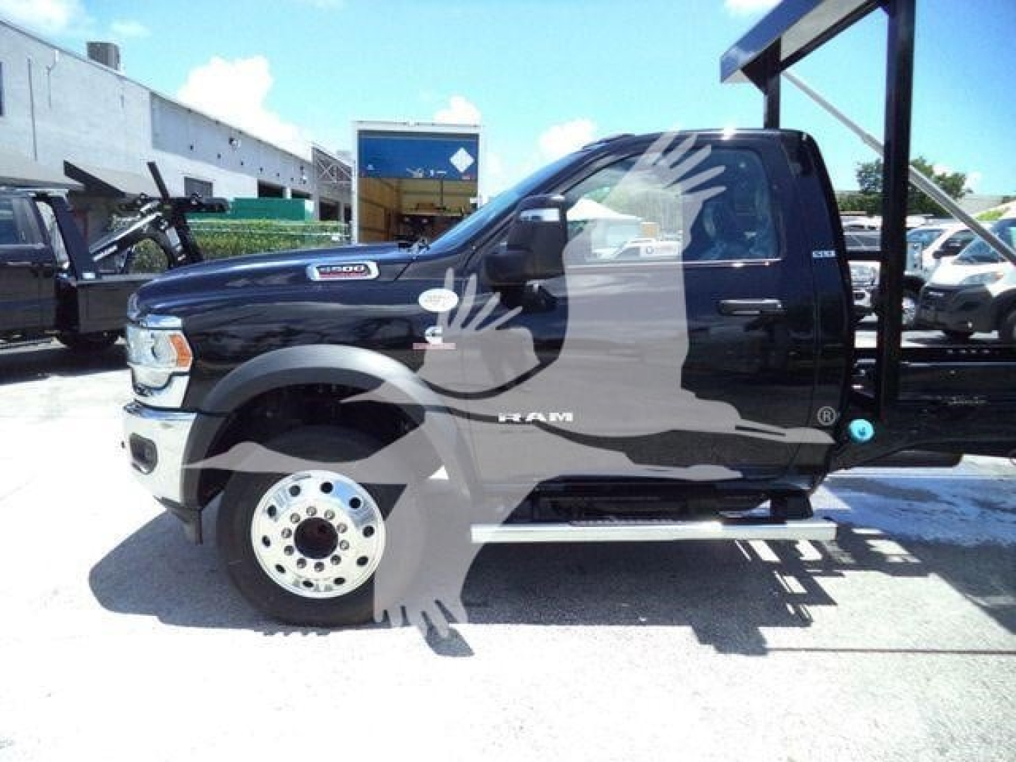 Ram 5500 truck side view showing cab and wheel, hooklift category visible with stock number label in background.