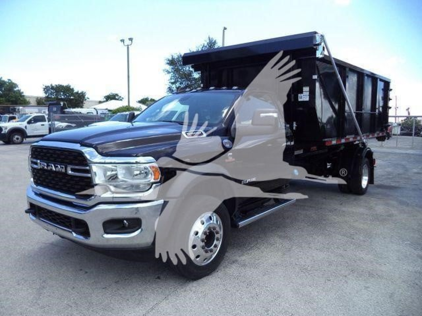 Ram 5500 SLT dump/tip truck side view showing front grille with RAM logo, dual mirrors, chrome bumper, and black dump body.