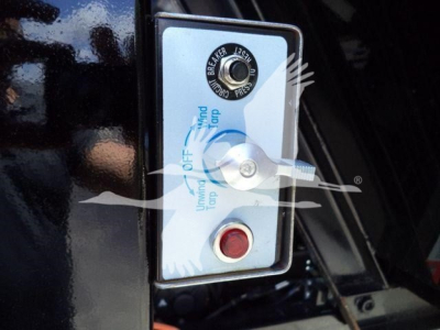Ram 5500 Hooklift control panel with ignition key switch and red start button, showing labels for pressure and turning directions.