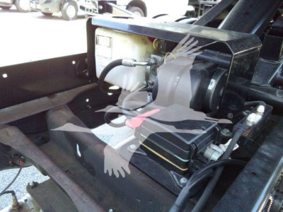 Ram 5500 SLT hooklift setup showing hydraulic reservoir and power unit with hoses and mounting bracket.