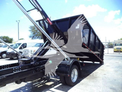 Ram 5500 hooklift truck bed with hydraulic arms and black dump bed visible, side wheel and chassis in view.
