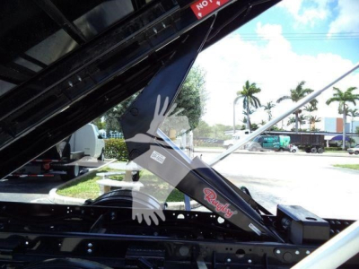Ram 5500 hooklift truck component showing a hydraulic arm with 'Ram' branding and structural black metal framing.