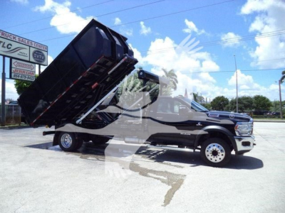 Ram 5500 SLT truck with a raised dump bed on a black truck body, side view showing front wheel and cab.