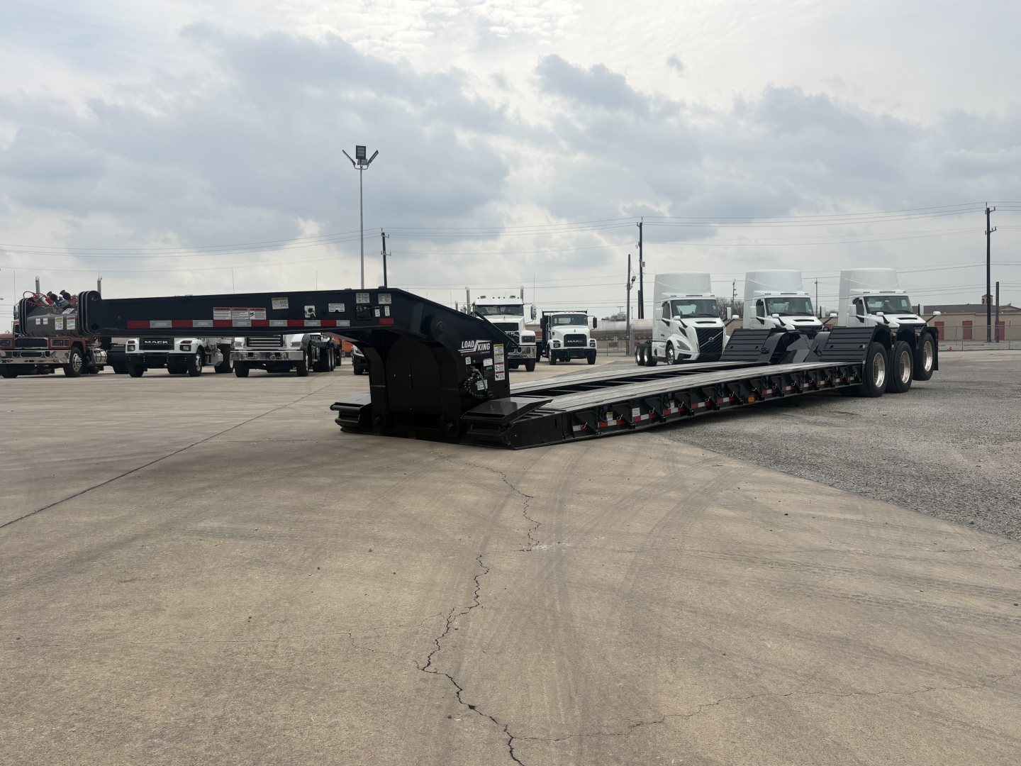 Load King lowboy trailer with 8'6"-wide deck and multiple axles, side view showing gooseneck and long flatbed section.
