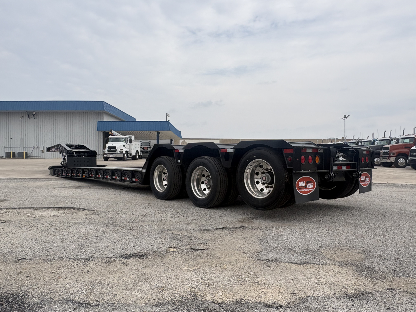 Load King trailer lowboy with multiple axles and wheels, aluminum frame, rear ramp area, VIN sticker area not visible.