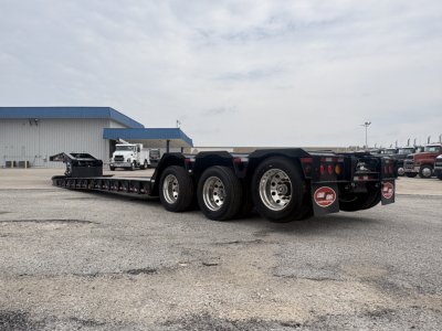 Load King trailer lowboy with multiple axles and wheels, aluminum frame, rear ramp area, VIN sticker area not visible.