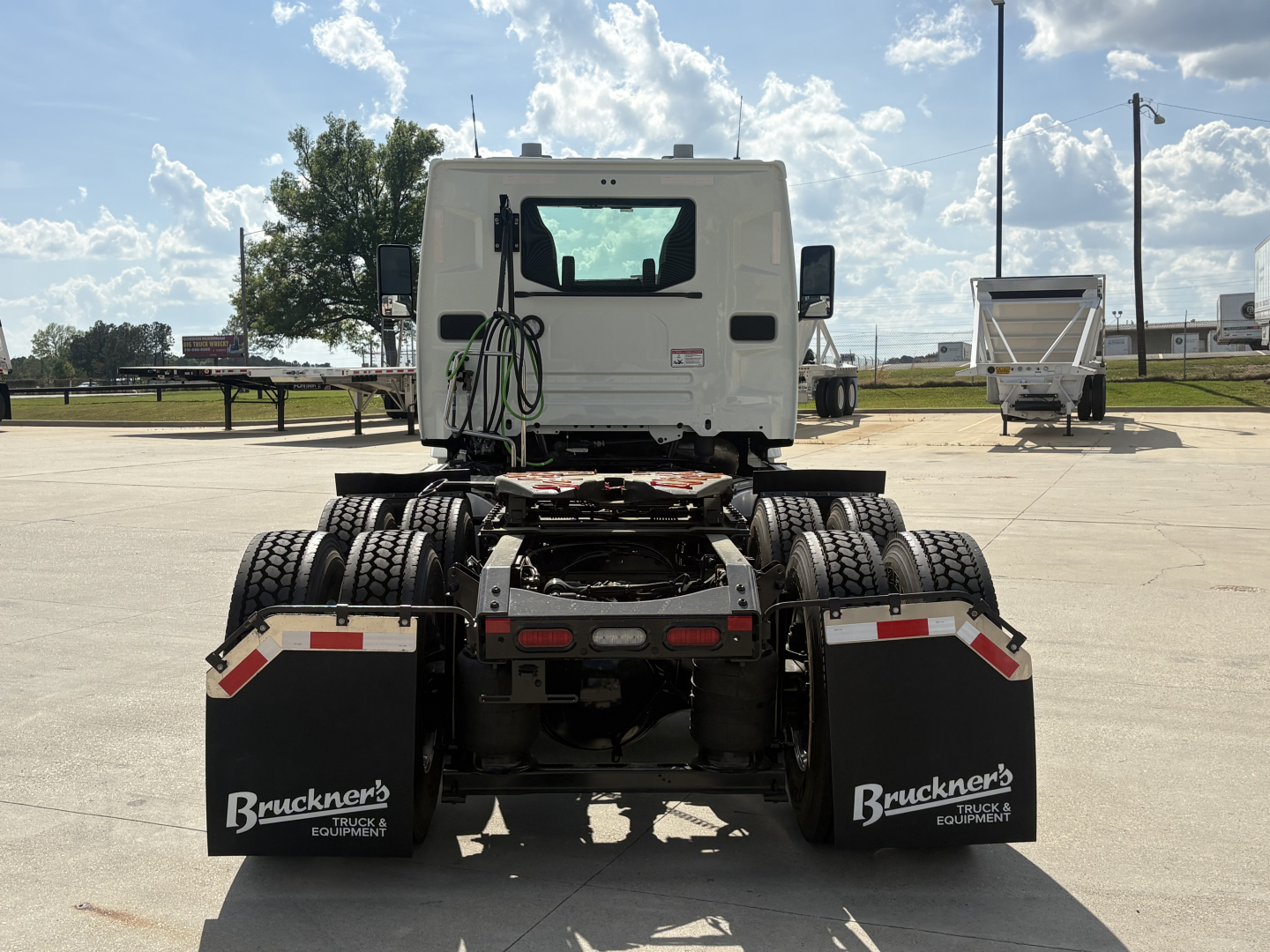 Rear view of a Mack AN64T tractor truck chassis showing dual rear wheels and mud flaps with Bruchner's Truck Equipment branding.