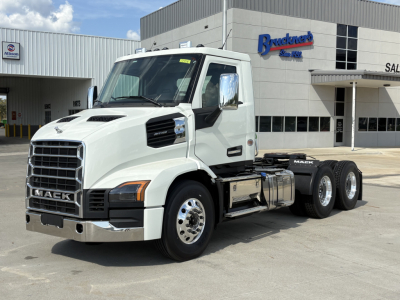 Mack AN64T conventional daycab truck in white parked outside dealership with front grille and chrome mirrors.